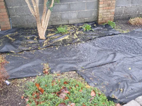 Weed barrier fabric membrane installed in a garden bed - Landscaping and Groundworks services